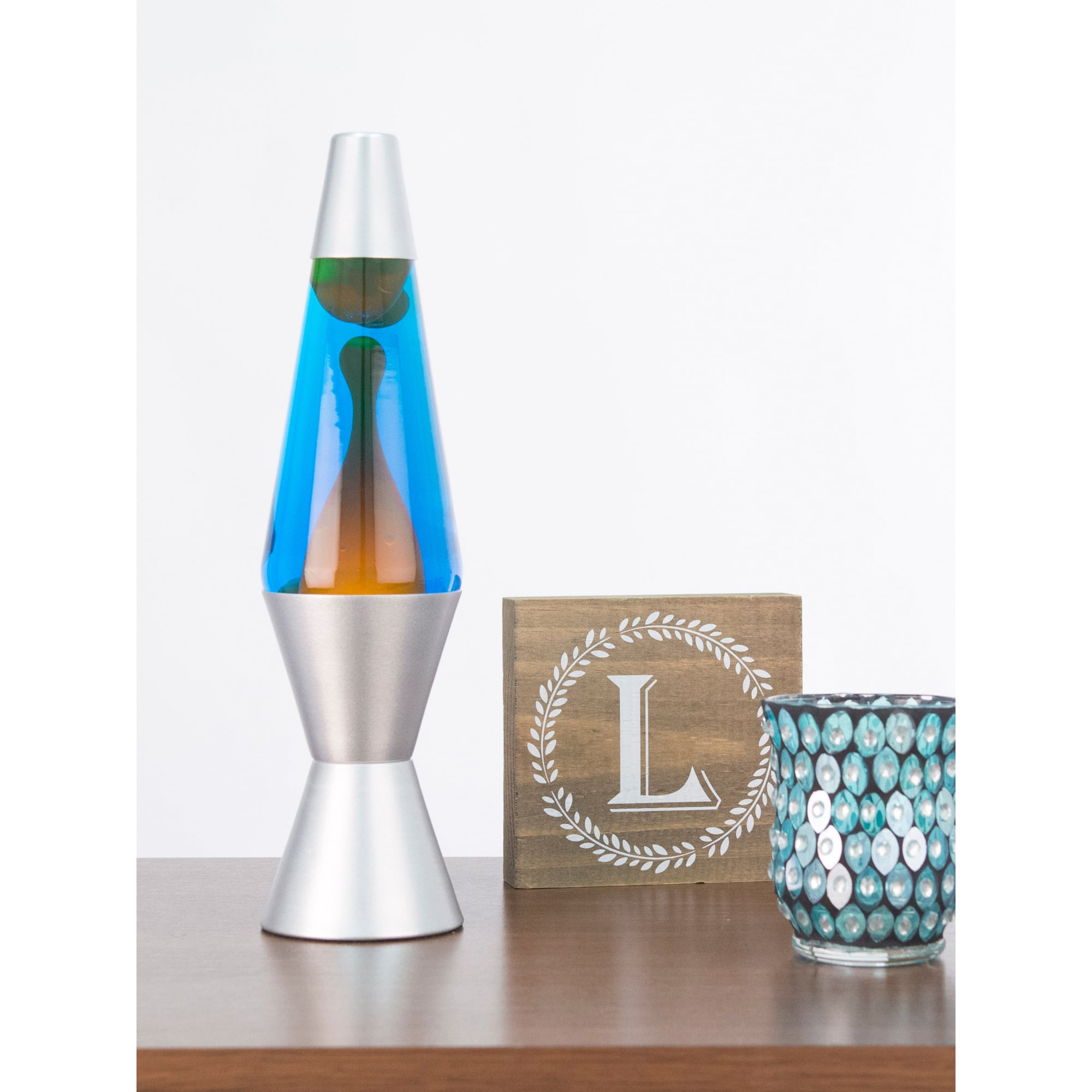 14.5” LAVA® Lamp – Orange/Blue/Silver on shelf with candle and sign