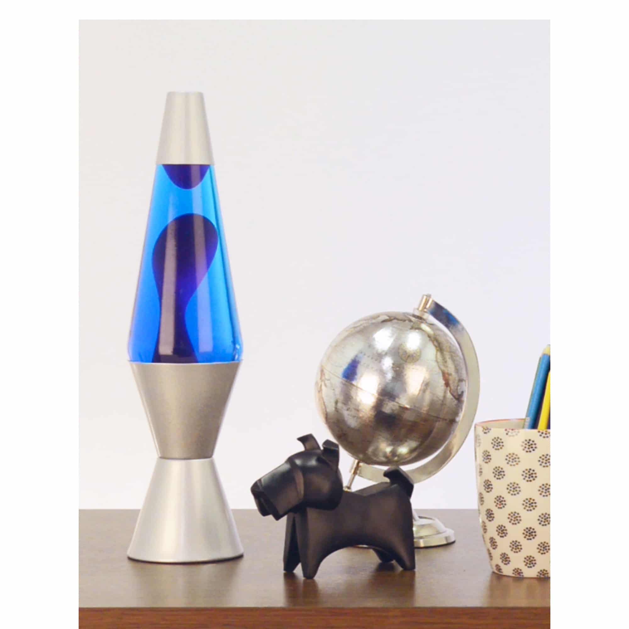 14.5” LAVA® Lamp – Purple/Blue/Silver on table with scotty dog figure, silver globe, and a pencil cup