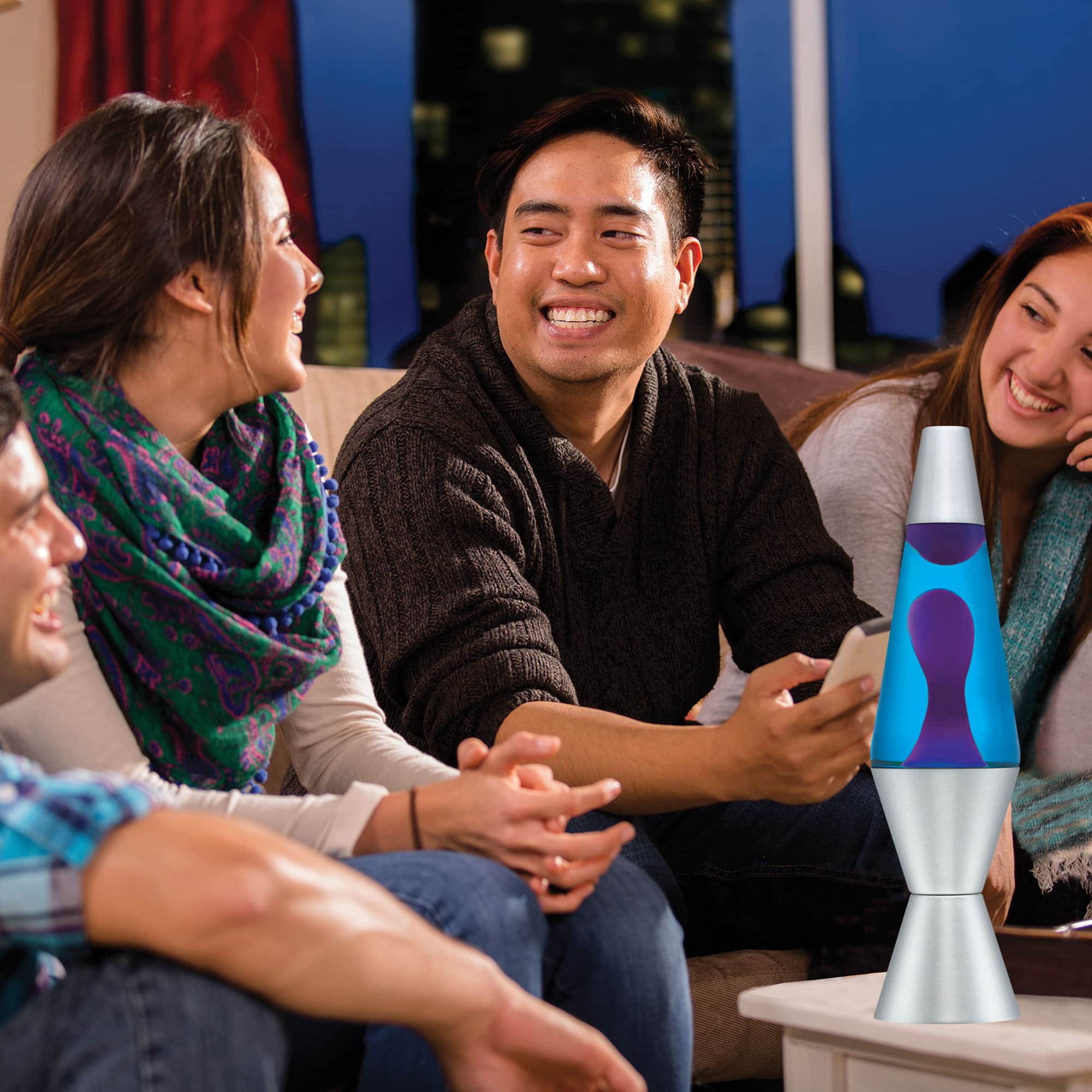 14.5” LAVA® Lamp – Purple/Blue/Silver on a coffee table at a party